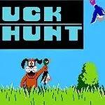 Koira hymyilee pitäen ankkaa suussaan keskellä ruohikkoa sinisen taivaan alla, ja vasemmassa yläkulmassa on teksti DUCK HUNT